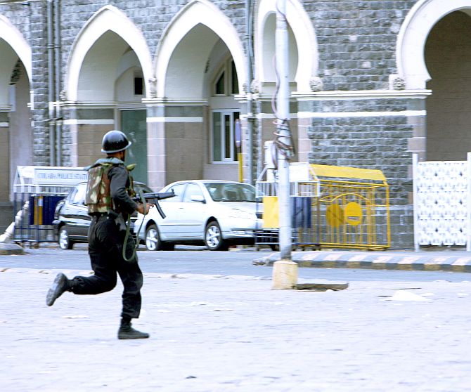 An NSG commando takes position outside the Taj hotel.