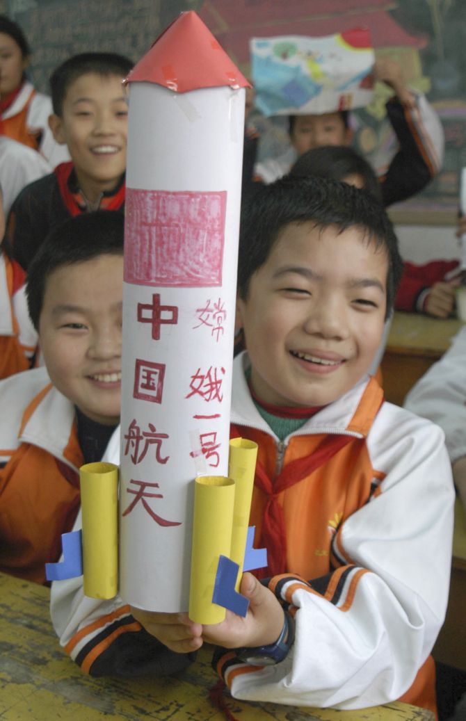 A pupil shows his handmade model of the Long March 3A carrier rocket in celebration of the successful launch of China's first lunar probe, Chang'e One, at a primary school in Huaibei, east China's Anhui province