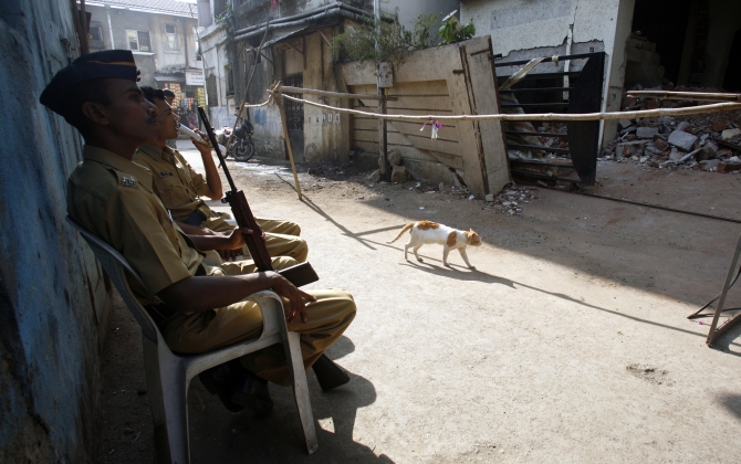 Policemen guard the entrance to the damaged Nariman House in Mumbai after the 26/11 attacks. 