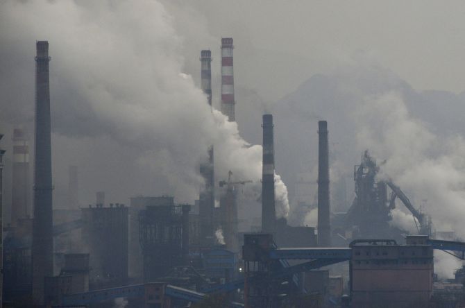 Smoke rises from chimneys and facilities of steel plants on a hazy day in Benxi, Liaoning province, China. A chronic shortage of natural gas is hurting China's plan to move away from burning coal to heat homes and offices, raising the prospect of more choking air pollution.