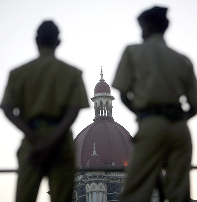 Policemen stand guard outside the Taj Mahal hotel.