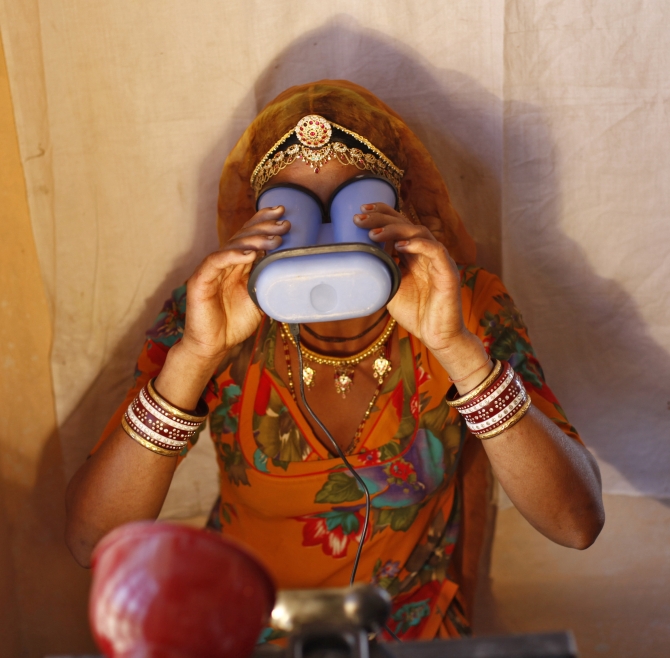 A villager goes through the process of eye scanning at Merta district in Rajasthan