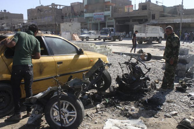 A policeman examines the remains of a vehicle that was used as a car bomb in Baghdad's Sadr City 