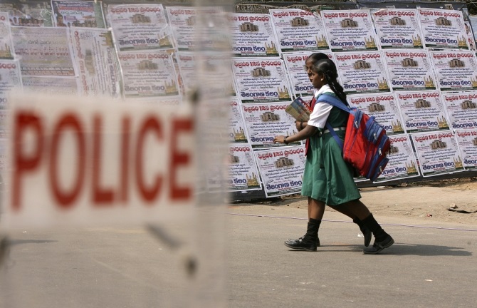 Schoolgirls walk past a police barricade in Hyderabad