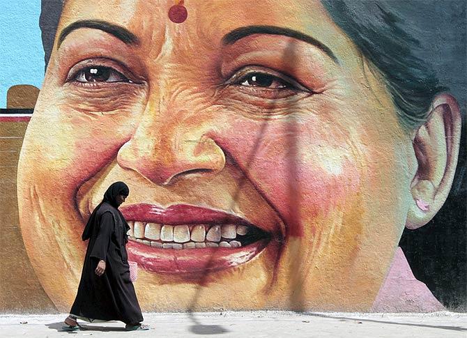 A woman walks past a portrait of Tamil Nadu Chief Minister J Jayalalithaa