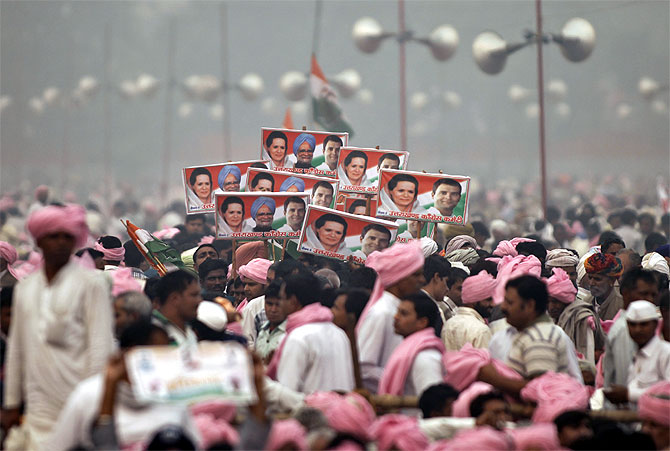 Supporters of Congress party hold posters of Prime Minister Manmohan Singh, Congress President Sonia Gandhi and Rahul Gandhi