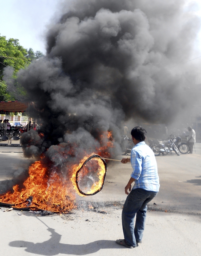 A protester burns a tyre during a protest against the creation of Telangana state, in Ananthapuram district in the southern Andhra Pradesh
