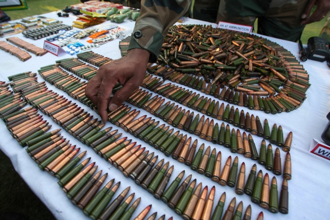 An army officer gestures at the arms and ammunition recovered during the Keran operation  