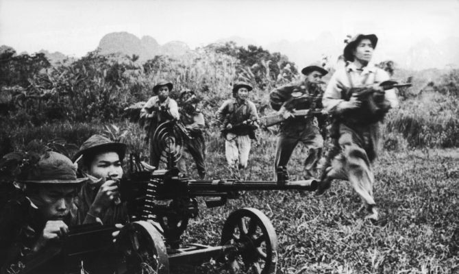 Viet Cong soldiers move forward under covering fire from a heavy machine gun during the Vietnam War in 1968. 
