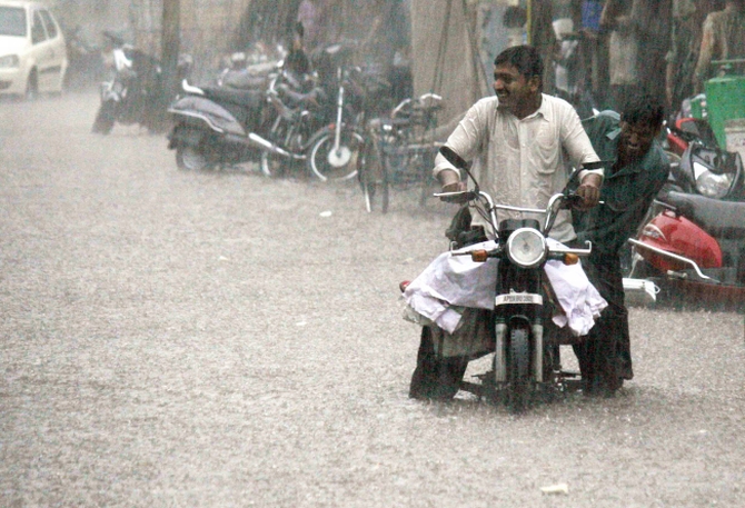 A motorist struggles as he wades his way through a water-logged street in Hyderabad