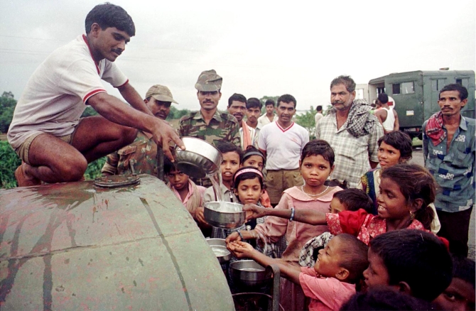 Soilders distribute drinking water at a village hit by the cyclone in 1999