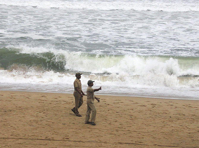 -Police direct people to move away as waves from the Bay of Bengal approach the shore at Podampata village in Ganjam district in the eastern Indian state of Odisha