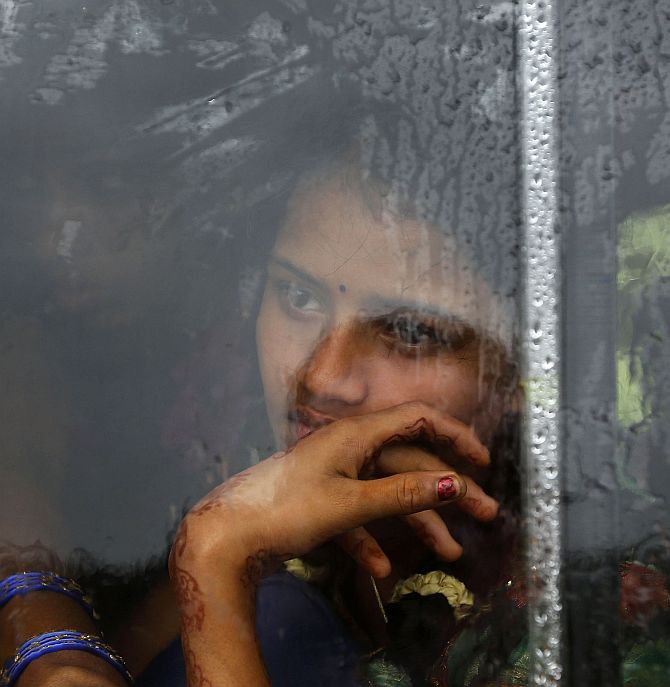 A girl looks out from the window of a bus travelling towards a relief camp in Donkuru village in Srikakulam district.