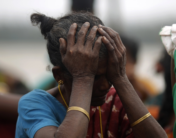 A woman holds her head after Cyclone Phailin hit Sunapur village in Ganjam district in Odisha