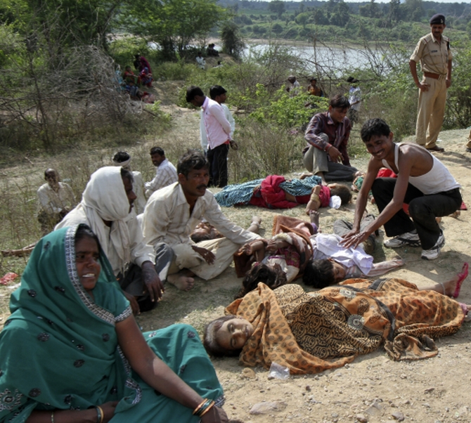 People cry next to bodies of victims killed in a stampede near Ratangarh temple