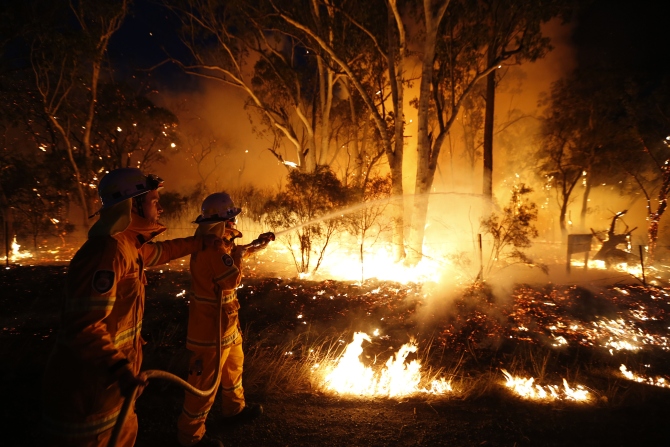 Firefighters attempt to extinguish a bushfire at the Windsor Downs Nature Reserve, near Sydney
