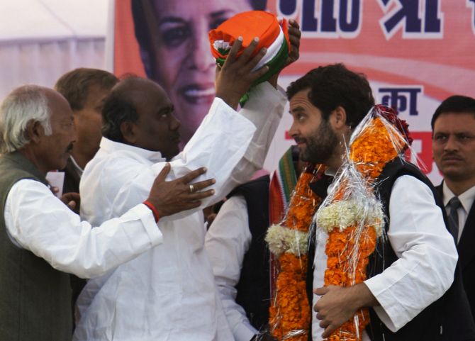 Rahul Gandhi is presented a turban by his party workers during an election campaign rally in UP