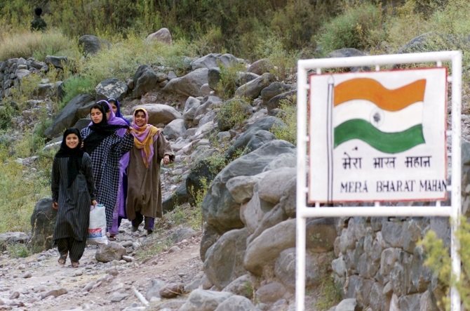 Kashmiri border village girls walk near a signboard that reads. 'My India (is) Great' at Odusaa, 127 kms west of Srinagar