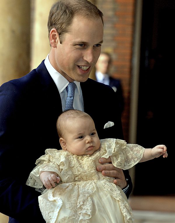 Britain's Prince William carries his son Prince George as they arrive for his son's christening