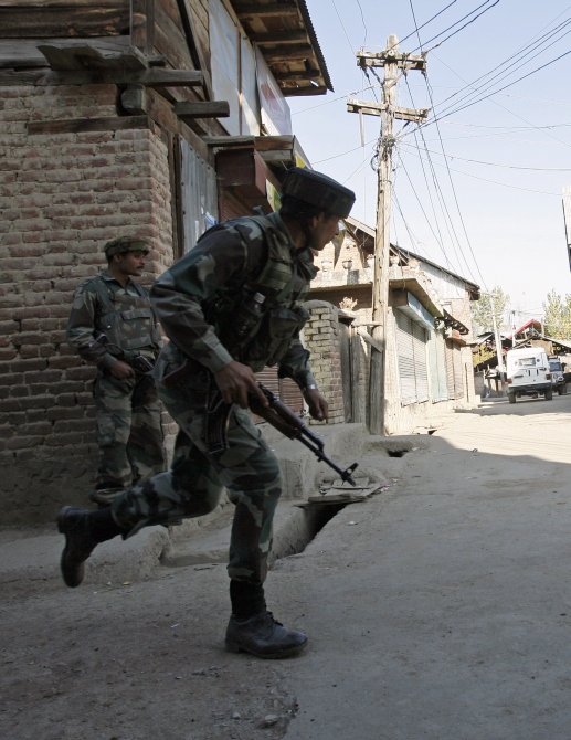 A soldier runs during a gun battle with suspected terrorists in Sopore, 48km north of Srinagar.