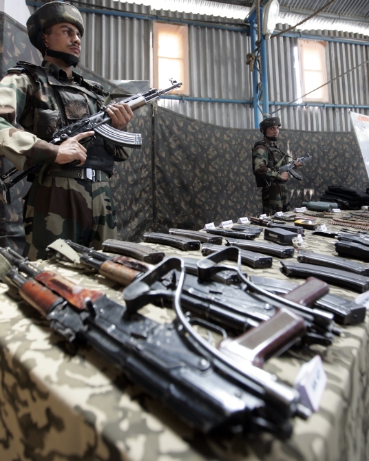 Army soldiers stand guard near seized arms and ammunitions during a news conference at an Indian army garrison in Kupwara, 90 km north of Srinagar