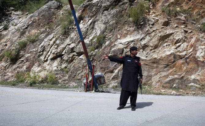 A police officer guards a check post on the outskirts of Gilgit 