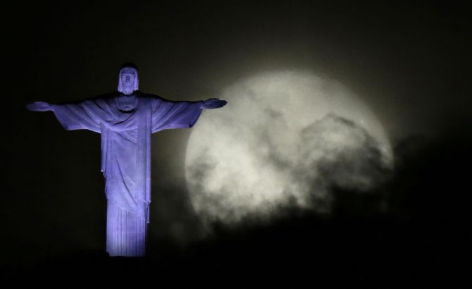 The moon is pictured next to the Christ the Redeemer statue in Rio de Janeiro