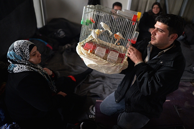 A man shows off his pet birds as new Syrian refugees arrive at the International Organisation for Migration at the Za'atari refugee camp in Mafrq, Jordan