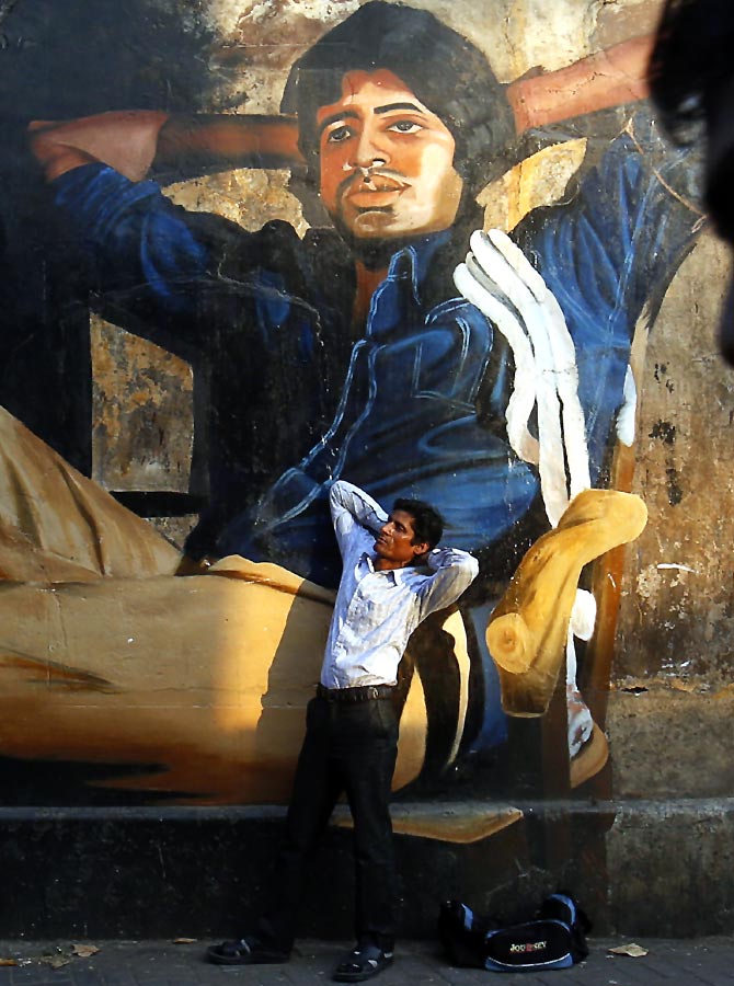 Ram Pratap Verma, an aspiring Bollywood actor, poses in front of a mural of Superstar Amitabh Bachchan.