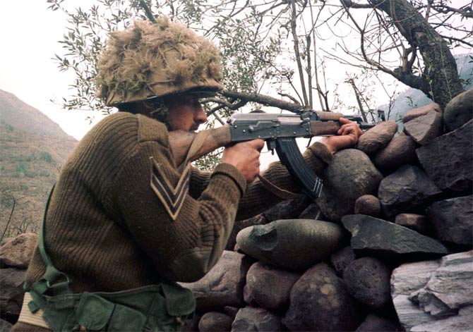 A Pakistani soldier aims his rifle towards Kashmir at his position on the Line of Control  in Chakoti