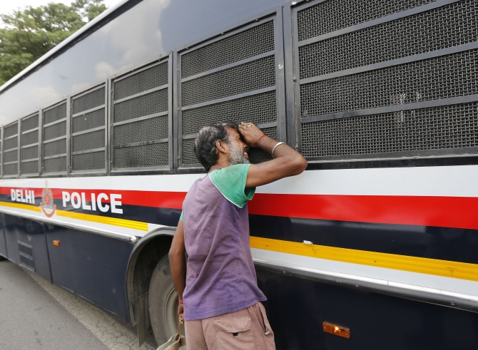 A man peeks into the police vehicle carrying four men, who were found guilty of the Delhi gang rape