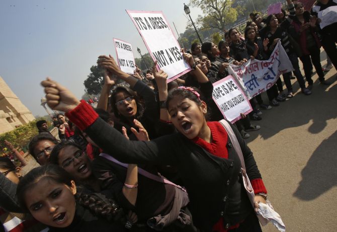 Demonstrators shout slogans as they hold placards in front of the India Gate demanding justice in the Delhi gang rape case