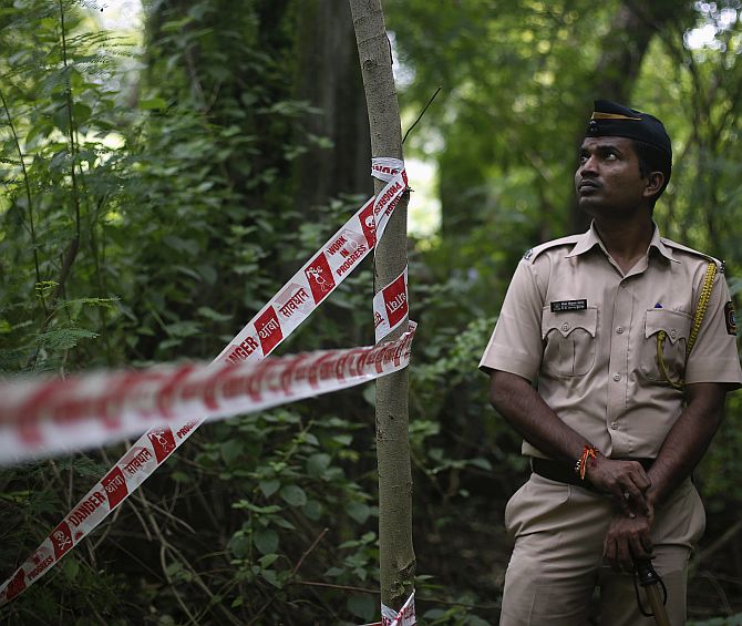 A policeman stands guard near the crime scene where a photo journalist was raped by five men inside an abandoned textile mill in Mumbai