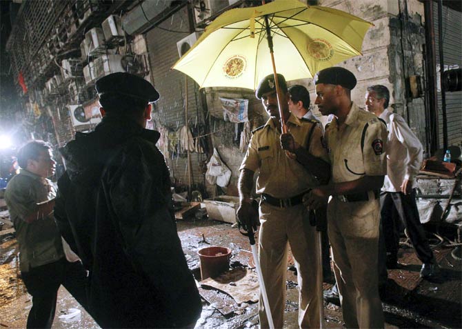 Policemen stand guard at the site of an explosion near Opera House in Mumbai