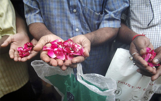 Residents carry rose petals to scatter at the entrance of Zaveri Bazaar, one of the sites of triple explosions in Mumbai