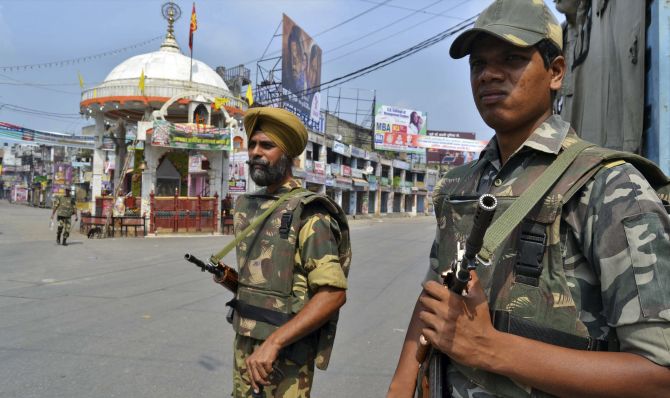 Soldiers stand guard on a deserted street during a curfew following communal violence in Muzaffarnagar and adjoining areas