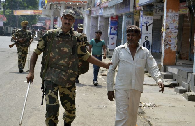 Soldiers detain two men for questioning during a curfew in Muzaffarnagar.