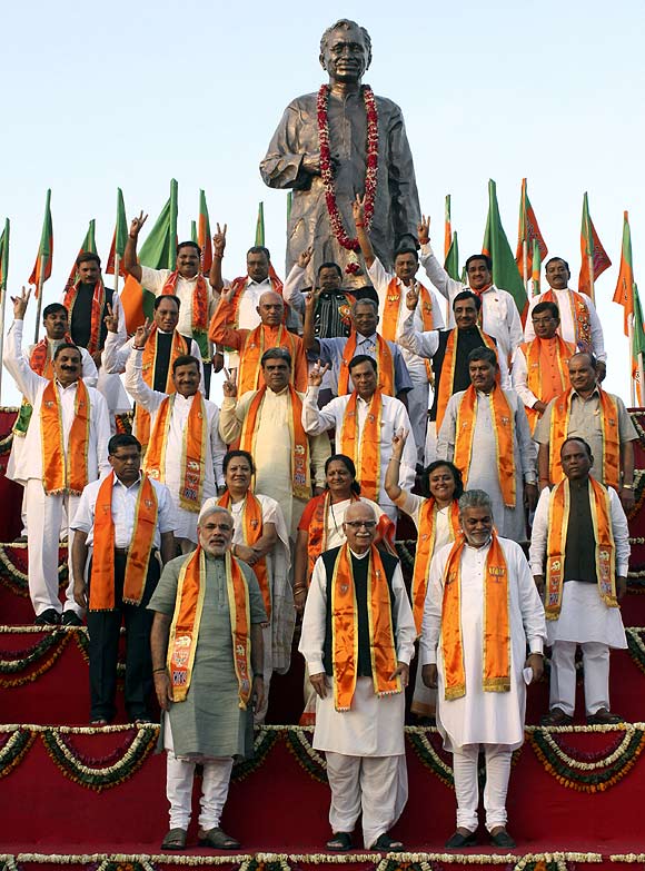 BJP leader Lal Krishna Advani and Gujarat's Chief Minister pose with their party candidates during an election campaign in Ahmedabad. At the back is a statue of Pandit Deendayal Upadhyaya