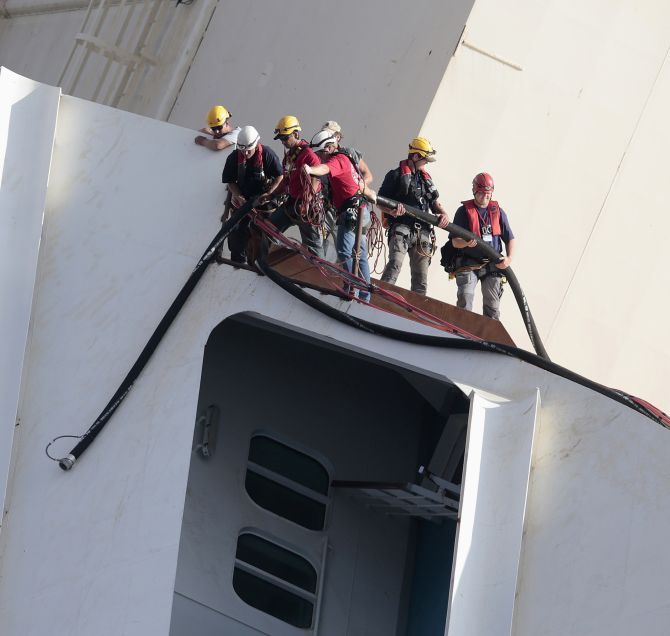 Salvage crew workers work on a side of the capsized Costa Concordia cruise liner outside Giglio harbour. 