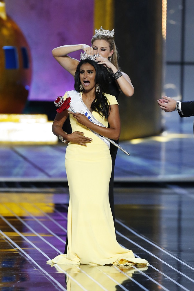 Miss America contestant, Miss New York Nina Davuluri reacts after being chosen winner of the 2014 Miss America Pageant as 2013 Miss America Mallory Hagan places a tiara on her head in Atlantic City, New Jersey
