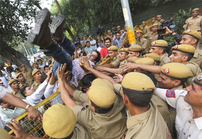 Policemen push a protester during a demonstration against the rising cases of rape in Delhi