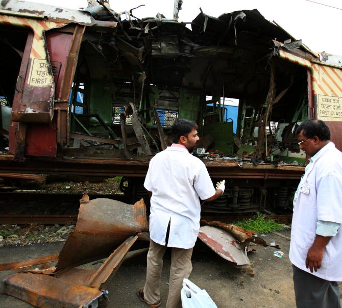 Forensics examine a train compartment destroyed by the serial blasts in Mumbai in 2006