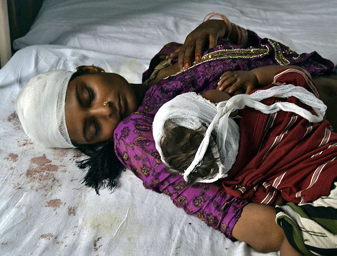 A woman and her child, who were injured in communal clashes, rest on a hospital bed in Muzaffarnagar