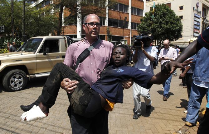 A journalist rescues a woman injured in a shootout between armed men and the police at the Westgate shopping mall in Nairobi 