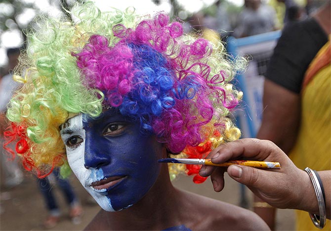 A cricket fan gets his face painted before an Indian Premier League game in Kolkata.