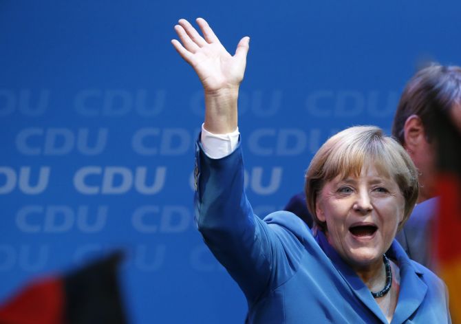 German Chancellor and leader of the Christian Democratic Union Angela Merkel waves to supporters as she celebrates with party members at the CDU party headquarters in Berlin