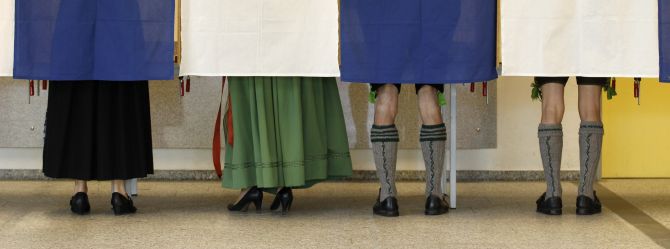 Voters Veronika Stuerzer, Monika Merk, Johann Merk and Michael Merk (L-R) wearing traditional Bavarian costume cast their ballots in the German general election