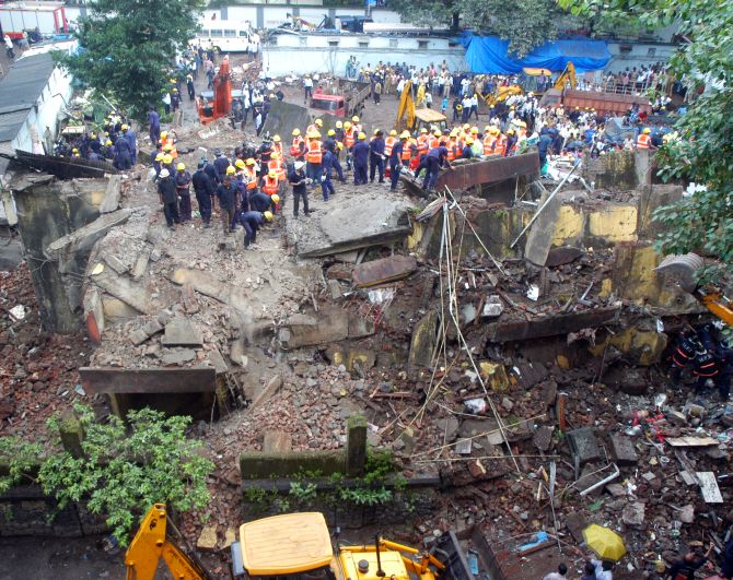 Firefighters and rescue personnel at the site of the building collapse in South Mumbai