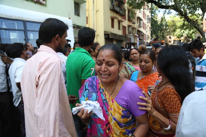 A family member of the person missing in the crash cries in Mumbai