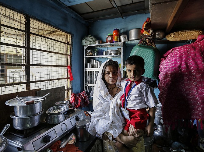 Nasreen Bano, a 22-year-old housewife, poses with her four-year-old son inside their one-room apartment in a residential building in Mumbai.